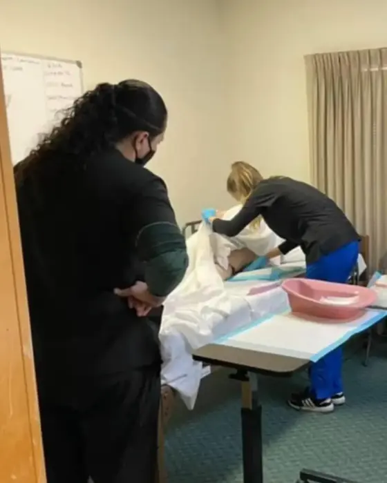 Students practicing bedside patient care during a supervised clinical skills lab